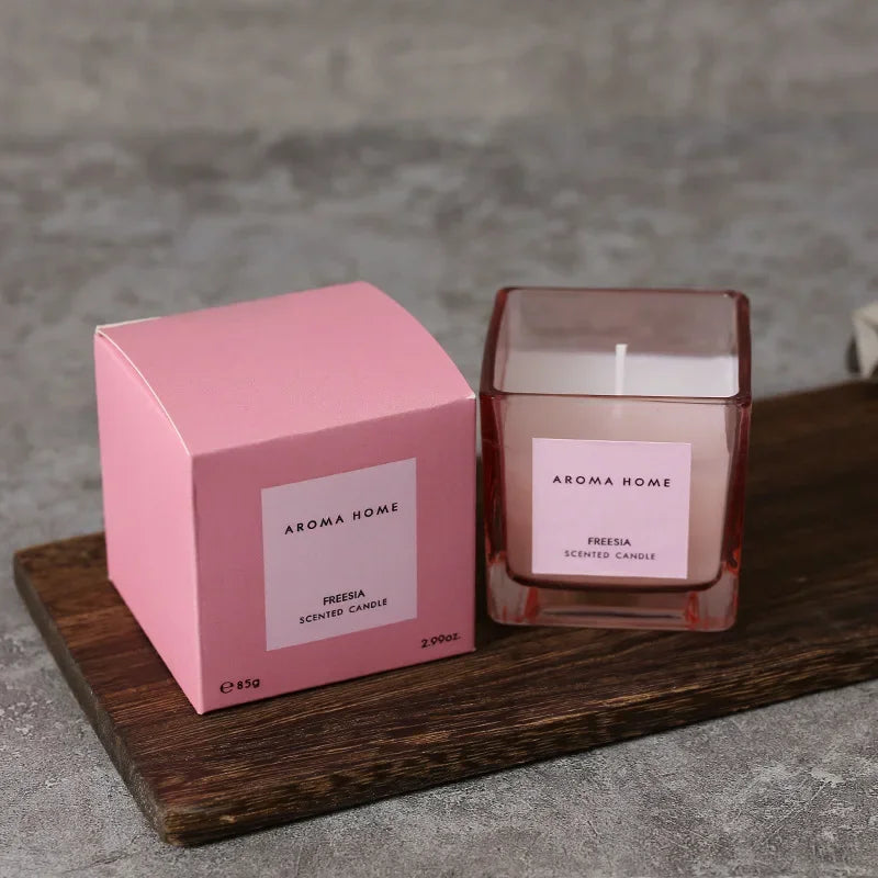 شمعة معطرة في وعاء زجاجي مربع وعتيق.