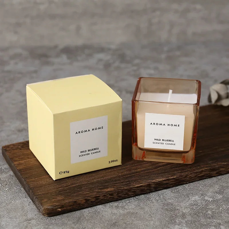 شمعة معطرة في وعاء زجاجي مربع وعتيق.