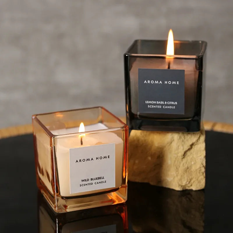 شمعة معطرة في وعاء زجاجي مربع وعتيق.