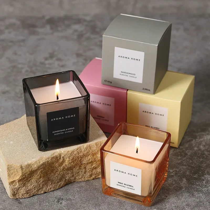 شمعة معطرة في وعاء زجاجي مربع وعتيق.