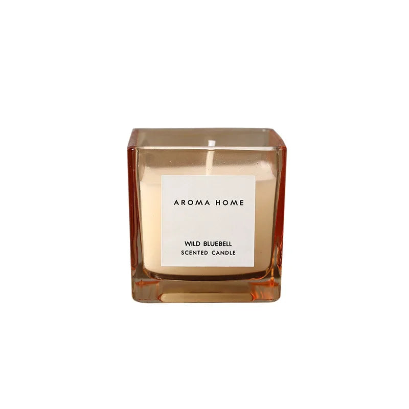 شمعة معطرة في وعاء زجاجي مربع وعتيق.