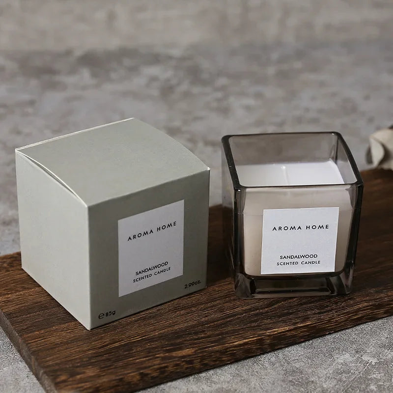 شمعة معطرة في وعاء زجاجي مربع وعتيق.