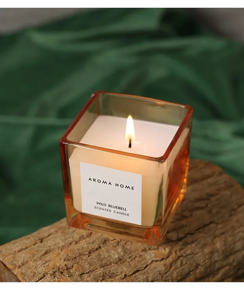 شمعة معطرة في وعاء زجاجي مربع وعتيق.