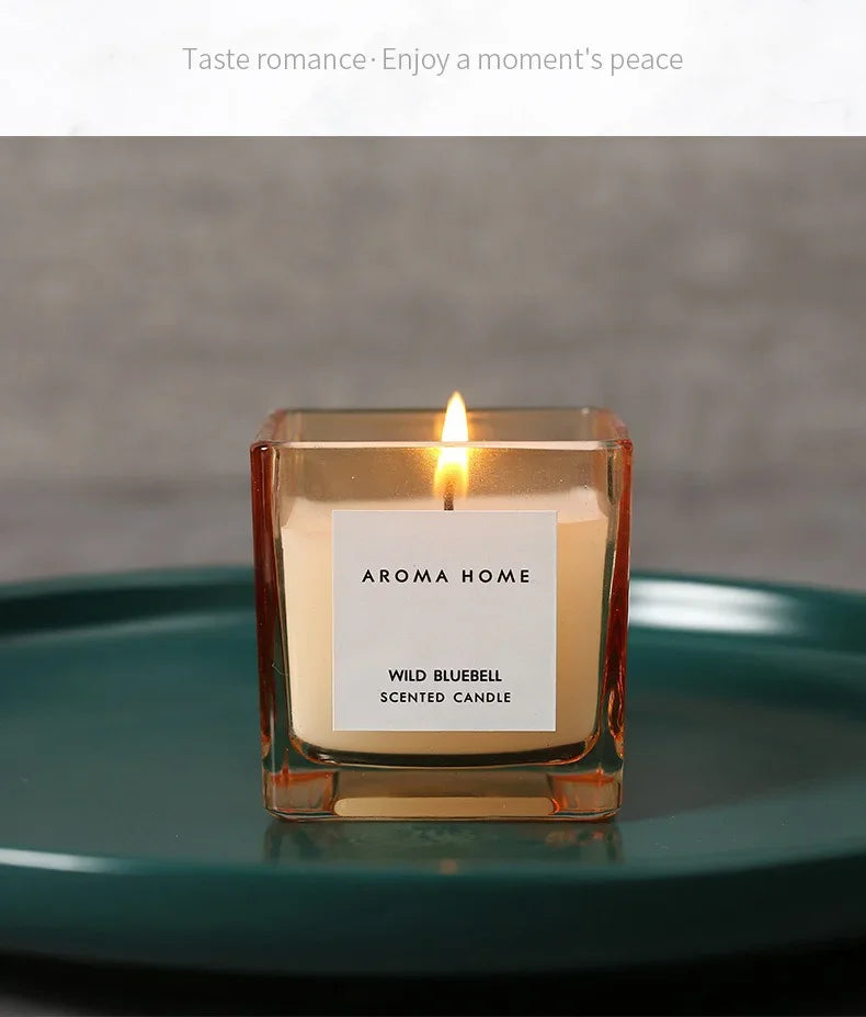 شمعة معطرة في وعاء زجاجي مربع وعتيق.