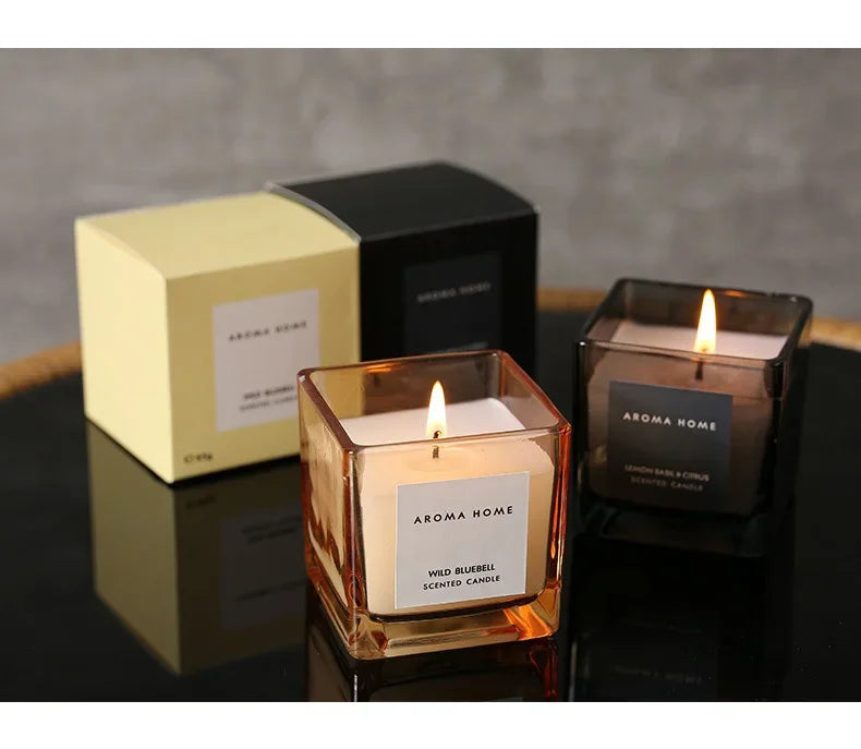 شمعة معطرة في وعاء زجاجي مربع وعتيق.