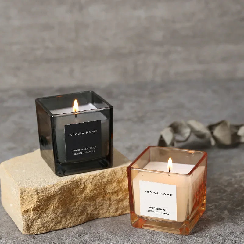 شمعة معطرة في وعاء زجاجي مربع وعتيق.