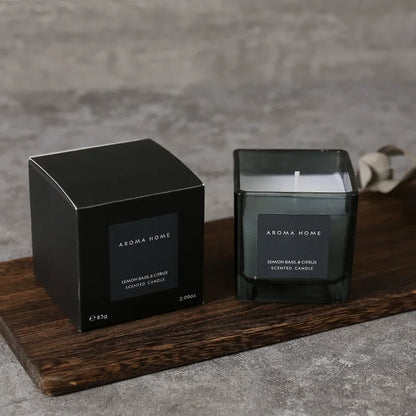 شمعة معطرة في وعاء زجاجي مربع وعتيق.