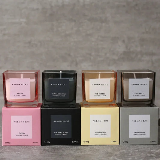 شمعة معطرة في وعاء زجاجي مربع وعتيق.