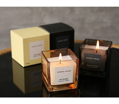 شمعة معطرة في وعاء زجاجي مربع وعتيق.